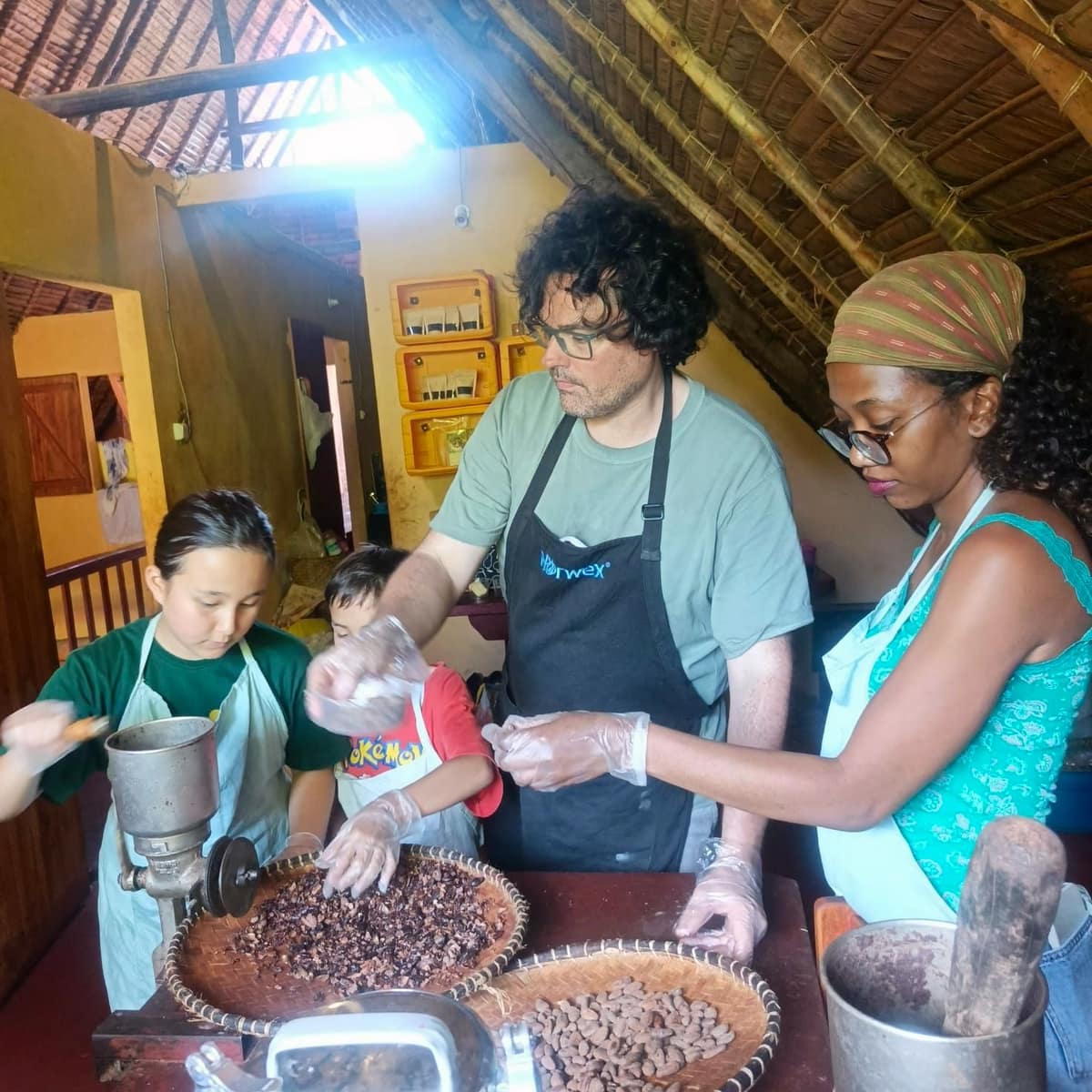 Une famille broie les fèves de cacao ensemble
